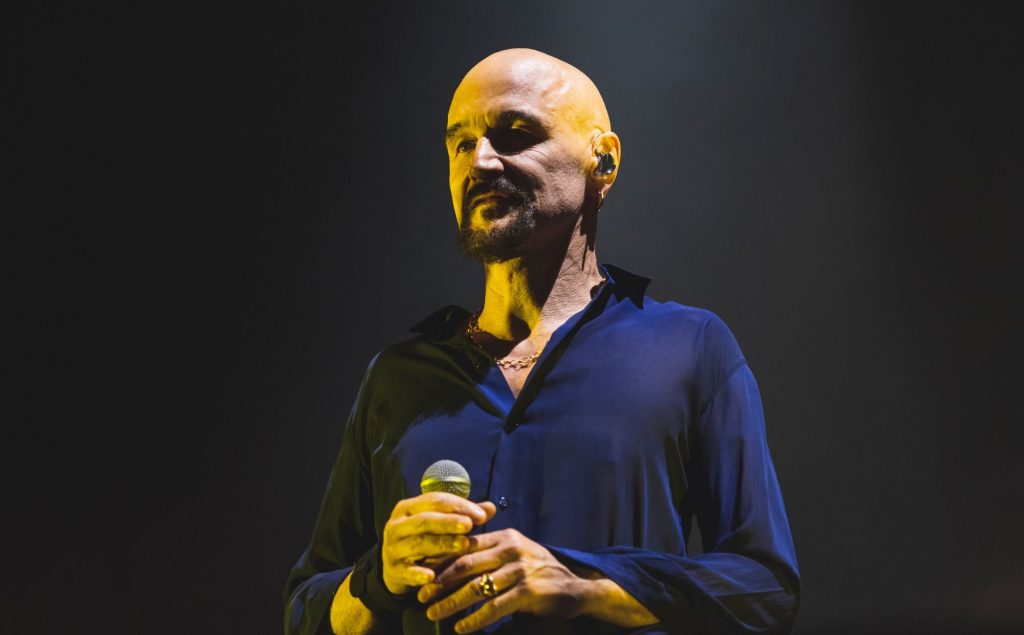 James’ Tim Booth Hits Out At Tommy Robinson And Far Right Protestors For Playing ‘Sit Down’: “It’s The Antithesis Of This Organisation”
